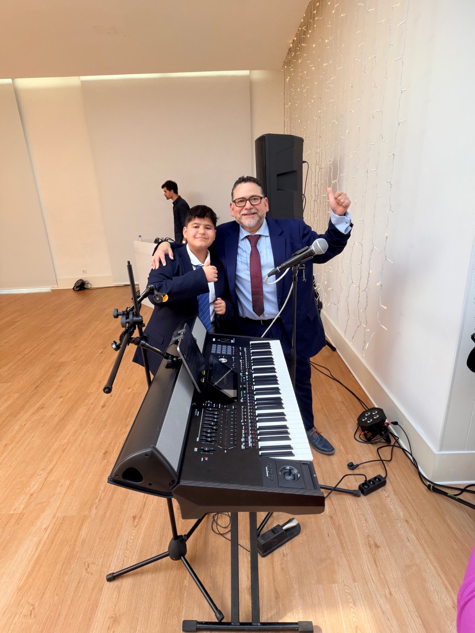 Armando y Mathias de LATITUDE en un evento con teclado, micrófono y equipo de sonido